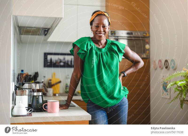 Portrait of a smiling mature woman standing in her kitchen people joy black natural attractive black woman happiness happy real people adult daily life adults