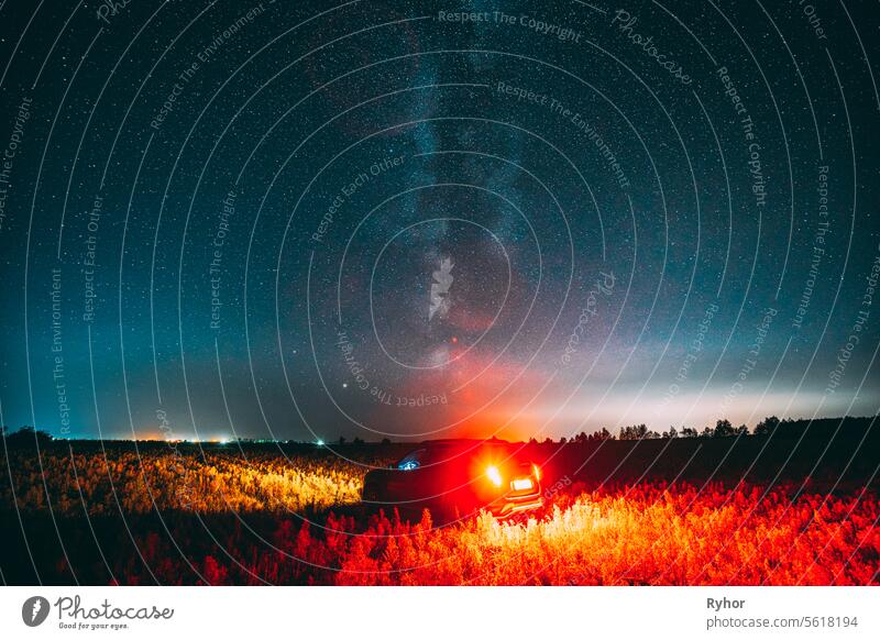 Milky Way Galaxy In Night Starry Sky With Glowing Stars Above Car SUV In Countryside Landscape. Milky Way Galaxy And Rural Field Meadow 4wd auto automobile