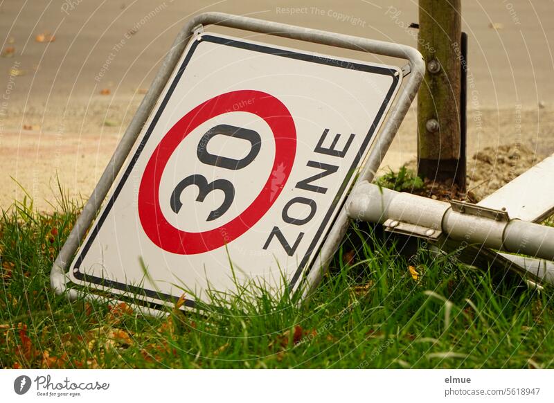 30 km/h zone traffic sign lying on the ground Road sign VZ 274-30 traffic-calmed zone 30 mph zone reclining Meadow permissible maximum speed Speed limit
