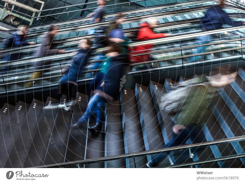 Stairs and escalators in a train station, with people hurrying up and down them rush hour Train station staircases Passengers Escalator stagger swift Movement