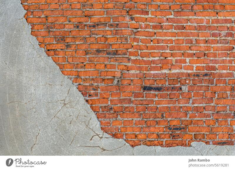 old bad brick wall with leftovers of gray peeled thick sandy plaster background eroded red block texture abstract cement grunge structure building surface
