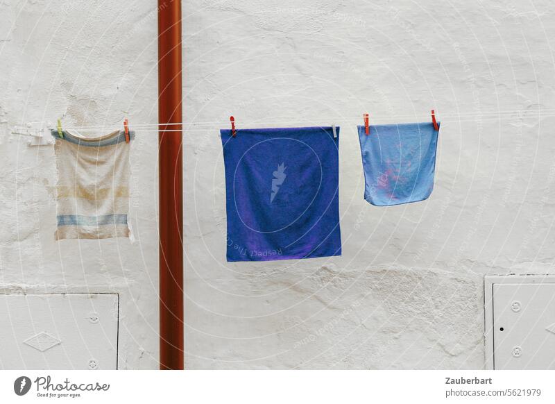 Blue and white square laundry hanging on a line in front of a white wall, forming a beautiful abstraction Laundry White Wall (building) Abstract Art