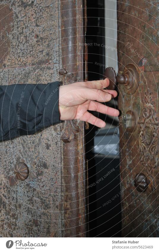 A man's hand opens an old front door old door Entrance Old town Open door Historic historic door