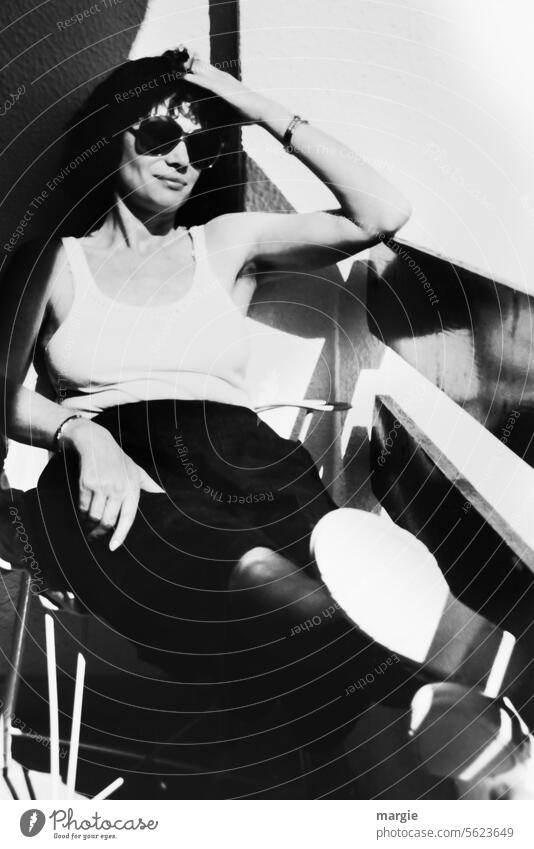Sunbathing on the balcony Woman portrait photo Image Black & white photo Analogue photo Balcony black-and-white Exterior shot Light Shadow sunglasses