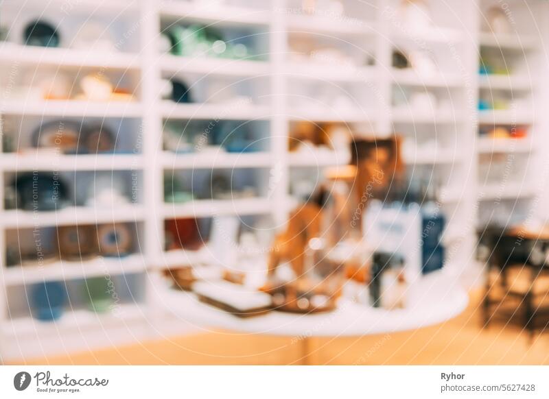 View of assortment of decor for interior shop in store of shopping center. View of shelving with dishes, bowls, plates. View of home accessories for dining room in shop fashion retail store. Abstract blur blurred boke bokeh background