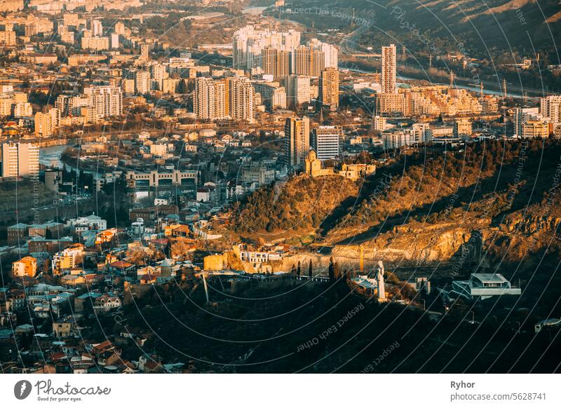 Tbilisi Georgia. Residential Quarters time . time elevated view Cityscape Famous Landmarks: Kartlis Deda Georgia mother Monument, Narikala Fortress, Tabor Monastery In Evening sunset