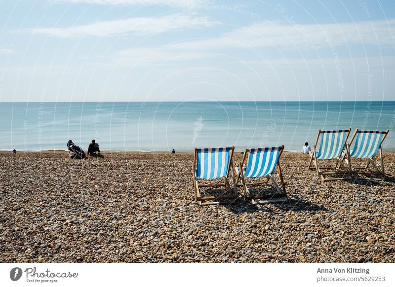 Sun loungers on the beach Beach and sea Idyll England Blue no clouds Blue sky Ocean blue white Sun chair Retro Gravel vacation