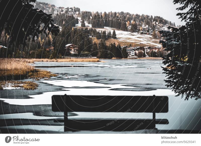 A bench in November in front of a frozen mountain lake Sunday Leisure and hobbies Freedom mountains Snow Switzerland Suisse Landscape Environment lenzerheide