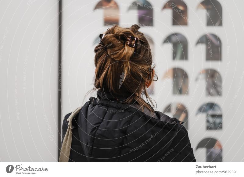 Visitor in the museum looking at art, head of a woman from behind, hood Museum Art look at Head Woman hairstyle view pinned up Rear view Hooded (clothing)