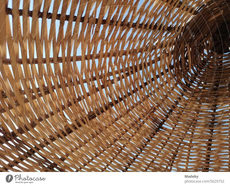 Large wicker parasol in beige and natural colors in summer sunshine on the beach of Ayvalik on the Aegean Sea in Balikesir province in Turkey wickerwork