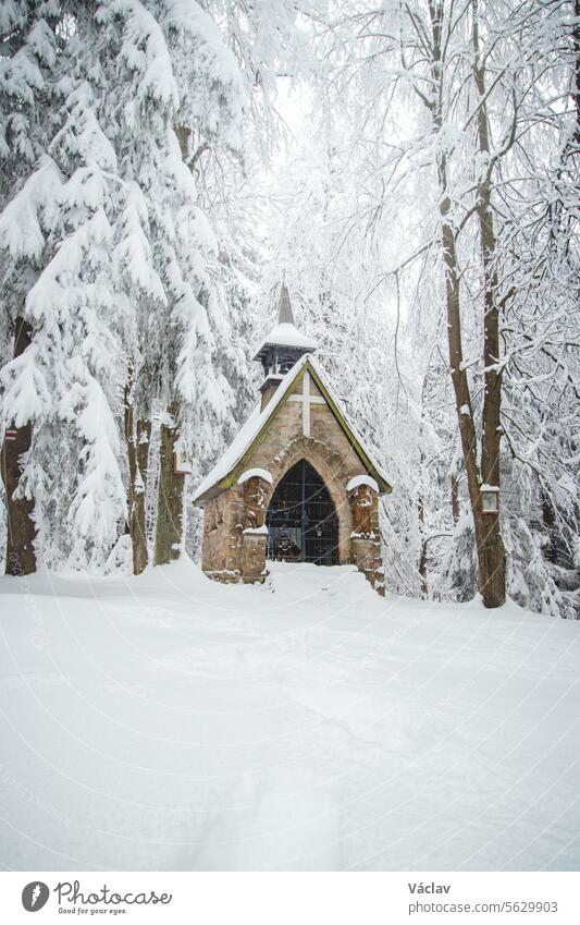 Stone chapel near the famous place Bily Kriz in Beskydy mountains, eastern Czech Republic. Snowfall in winter months snow moody winter scene mist white sunrise