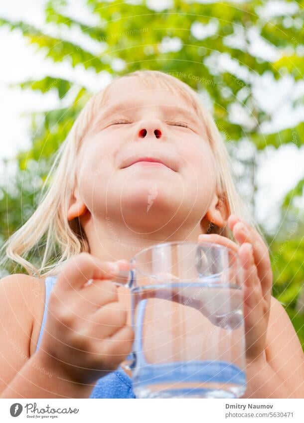 Child enjoying drinking water outdoors 4-5 years aqua beverage blonde blue caucasian child childhood clear closed eyes cup enjoyment expression eyes closed