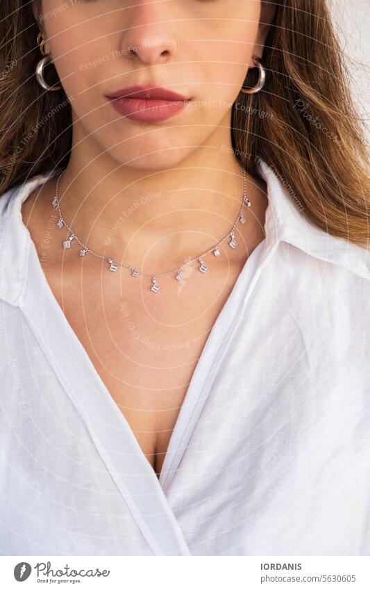 Young woman wearing a silver clear necklace and silver earrings. accessories attractive beautiful beauty brunette caucasian chain dainty diamond elegance face