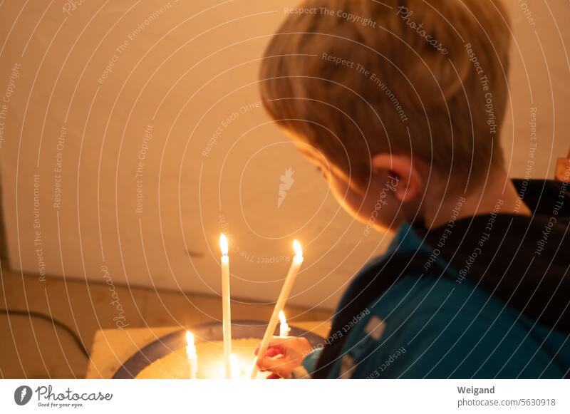 Child lighting a candle in a church shoulder stand Grief Hope blessing religion Catholic Protestant Church service Boy (child) Light Advent