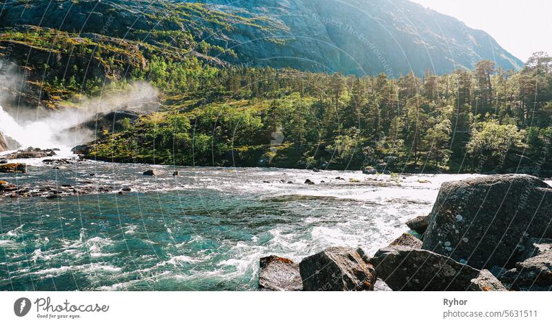 Kinsarvik, Hordaland, Norway. Waterfall Nykkjesoyfossen In Hardangervidda Mountain Plateau. Spring Sunny Day. Height Of 49 m. Famous Norwegian Landmark And Popular Destination. Panorama. Bold Colors