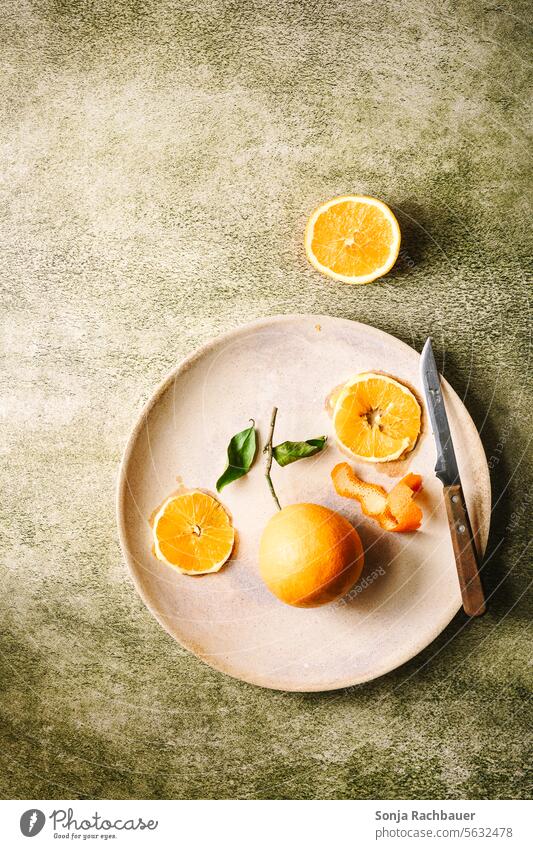Oranges on a plate. Green table, top view. fruit Plate Fruit Juicy Mature Slice plan Table Vitamin Diet Tropical Citrus fruits Fresh Organic Yellow Leaf