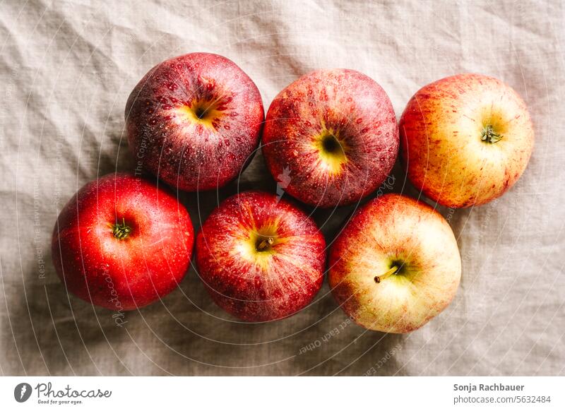 Red apples on a beige linen tablecloth. Top view. Apple plan fruit Fresh Juicy Mature naturally Organic produce Vitamin-rich Harvest Autumn Healthy Eating