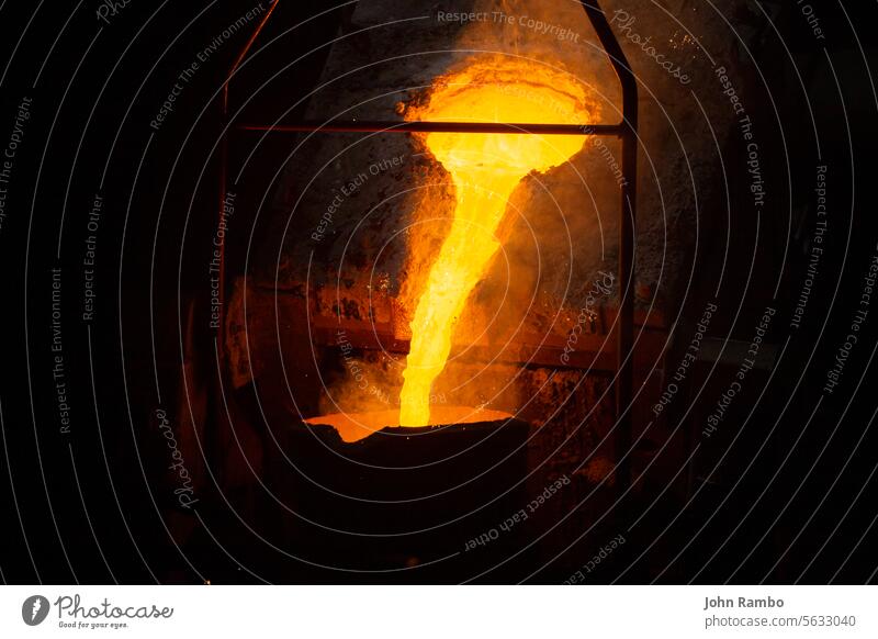 a process of ladle filling with molten hot steel from furnace with smoke - close-up with selective focus flow industrial metal iron metalurgy casting dark