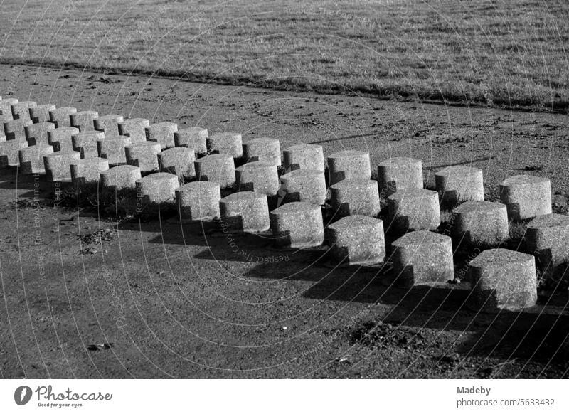 Concrete breakwater as coastal protection on the dike in the fall in sunshine in Bensersiel near Esens on the coast of the North Sea in East Frisia in Lower Saxony in black and white