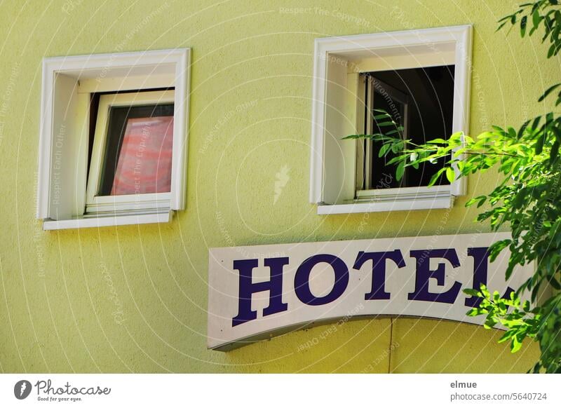 HOTEL lettering on the green building wall with two windows Hotel Window Accommodation sign travel Tourism Hostel Accommodation service Hotel room