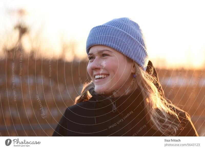 LAUGHING - CHEERFUL - SUNNY WINTER MOOD Woman 18 - 30 years Nose ring side view Cap blue cap Laughter Happiness fortunate naturally Sunlight Winter Happy hours