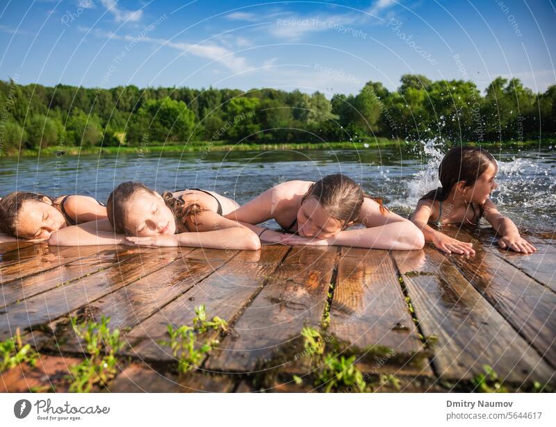 Children enjoying summer holidays at a lake calm candid carefree child childhood children deck enjoyment friends friendship girls group leisure lifestyle little