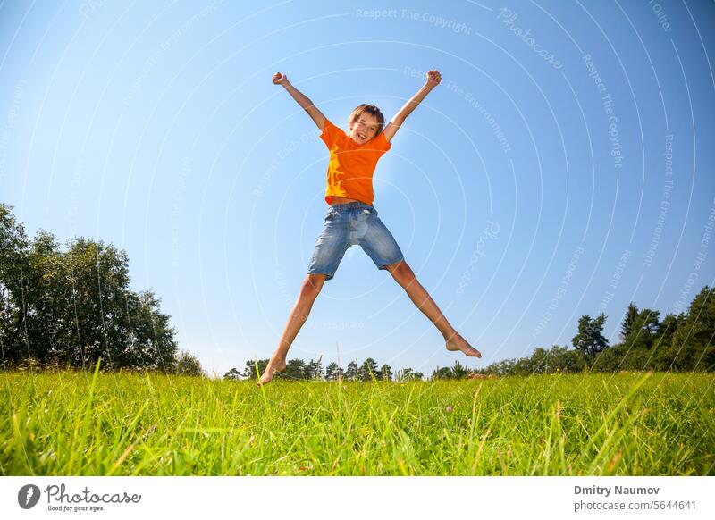 Kid jumping on the sunny meadow outdoors 12-13 years Expressing Positivity activity boy carefree casual clothing caucasian child childhood day emotion energy