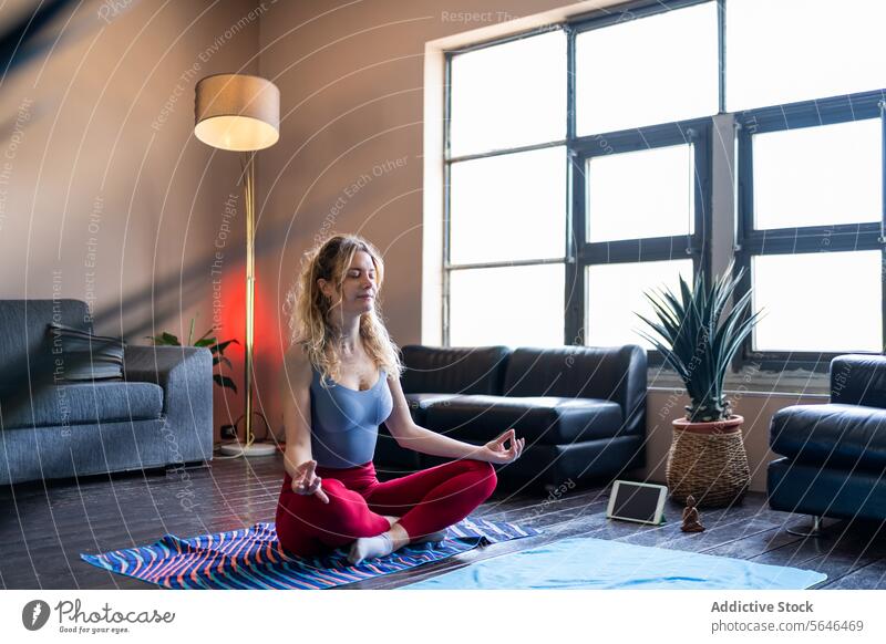Woman practicing yoga at home with sunlight woman meditation living room serene pose wellness health fitness calm peace practice indoor lifestyle mindful