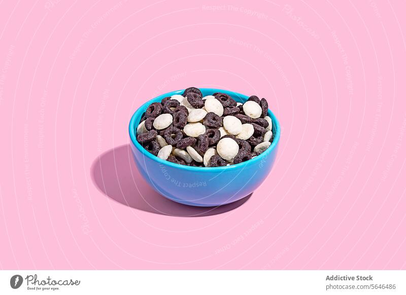 Colorful bowl of assorted chocolate candies on pink candy background confectionery sweet snack variety colorful blue dessert treat food sugar indulgence tasty