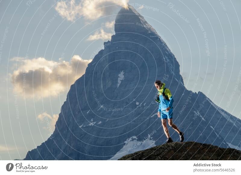 Trail Runner in the Mountain Wilderness trail runner mountain peak adventure nature wilderness outdoor sport activity rock precipice majestic hiking sky cloud