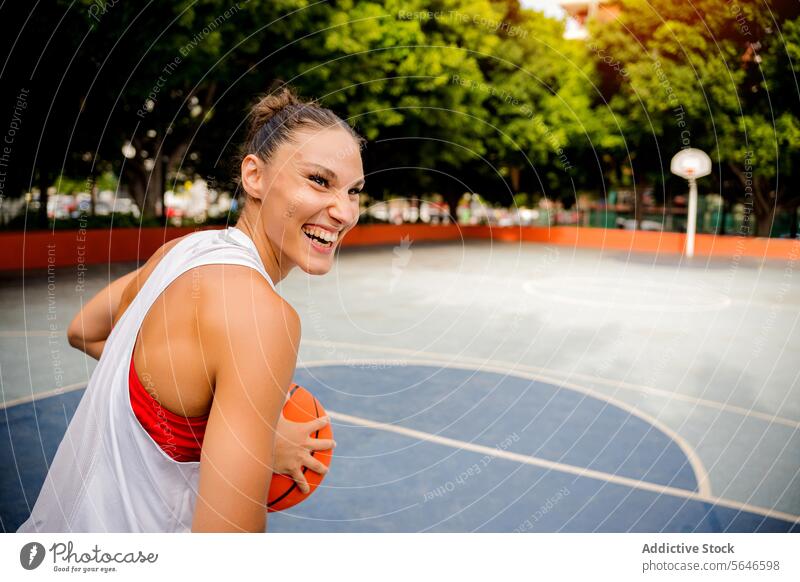 Laughing woman playing basketball on court during daytime Sportswoman Basketball Play Ball Player Cheerful Training Enjoy Woman Playground Game Smile Activity