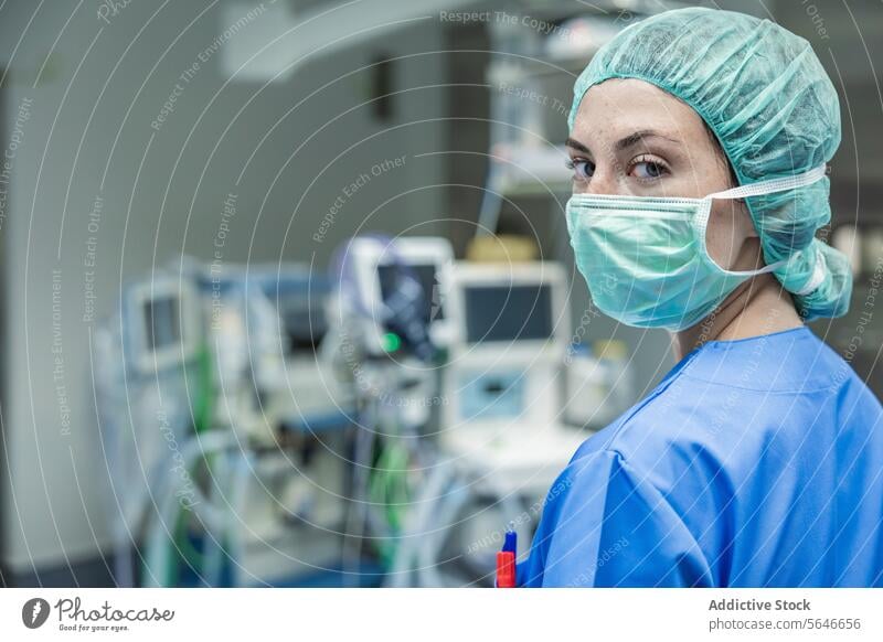 Female surgeon in uniform with medical mask and cap standing at hospital woman doctor clinic work health care medicine surgery equipment operating room protect