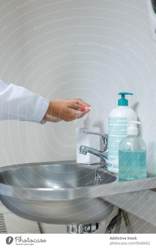 Crop female washing hands with alcohol gel in sink doctor hygiene liquid bottle nurse dispenser woman sanitizer health care disinfect antibacterial sanitary