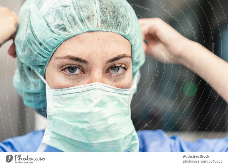 Female surgeon in hospital with medical mask and cap woman uniform doctor clinic protect professional health care medicine specialist nurse sterile prevent