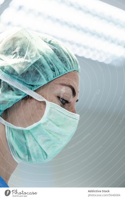 Female doctor in protective mask and cap looking down at hospital woman surgeon clinic uniform health care professional specialist prevent medicine medical