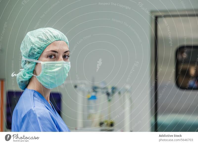 Female surgeon in uniform with medical mask and cap standing at hospital woman doctor clinic work health care medicine surgery equipment operating room protect