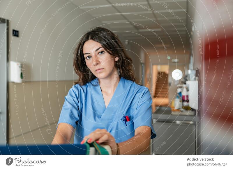 Professional female doctor sitting at hospital corridor in clinic woman medical uniform nurse medicine specialist health care professional portrait confident