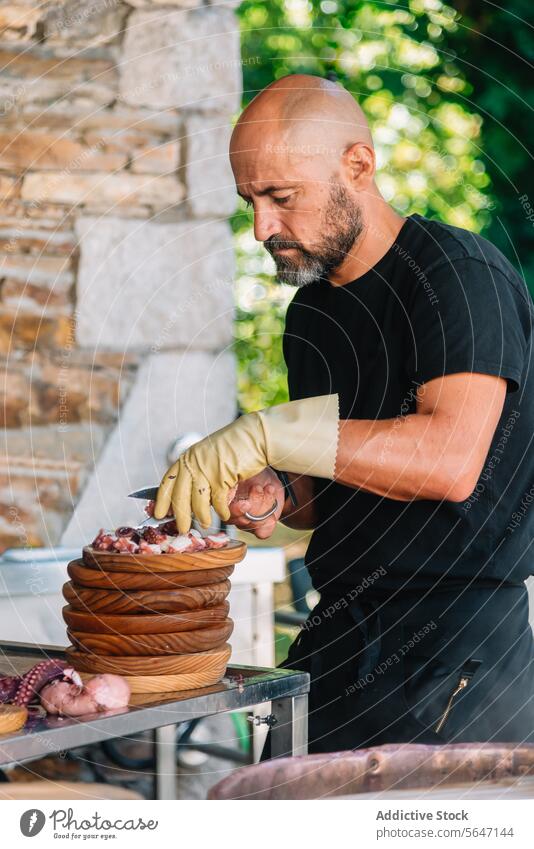 Focused Chef in gloves Slicing Octopus on wooden plates in Galicia chef slicing octopus traditional dish concentration expertise knife perfection culinary