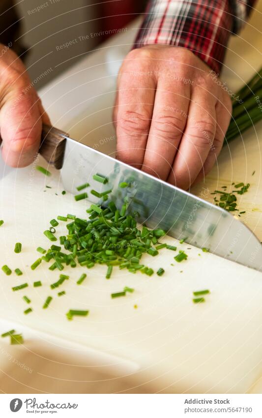 Closeup of anonymous person chopping Fresh Chives fresh chives hands close-up cutting board green cooking preparation herbs culinary skill kitchen pieces