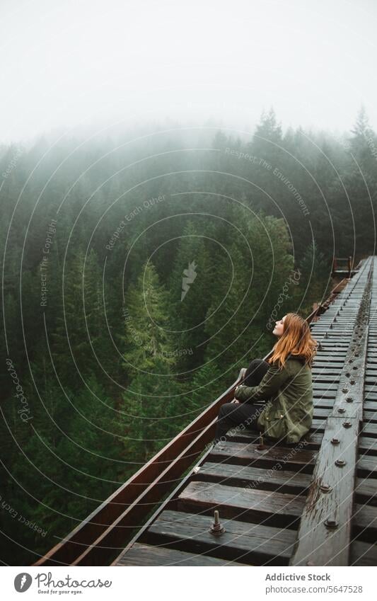 Contemplative woman on misty forest railway solitude contemplation reflection evergreen vancouver island british columbia canada nature outdoors scenic