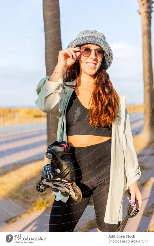 Fashionable attractive female with skates woman inline sunglasses hat fashionable happy brunette beautiful roller lifestyle rollerskating sunlight