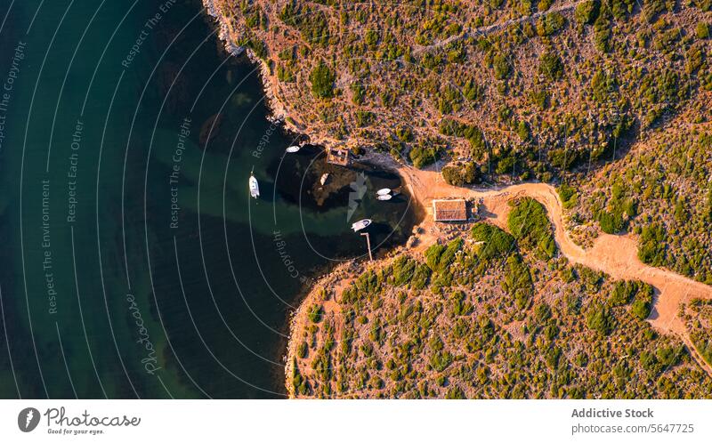 Aerial view of Sanitja natural port in Menorca with winding road along a rugged coastline Cavalleria Balearic Islands aerial view harbor cliff landscape nature