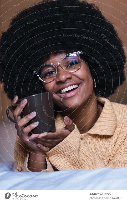 Smiling black woman with coffee in bed rest relax weekend free time home female african american afro comfort bedroom happy eyeglasses young lady drink cheerful