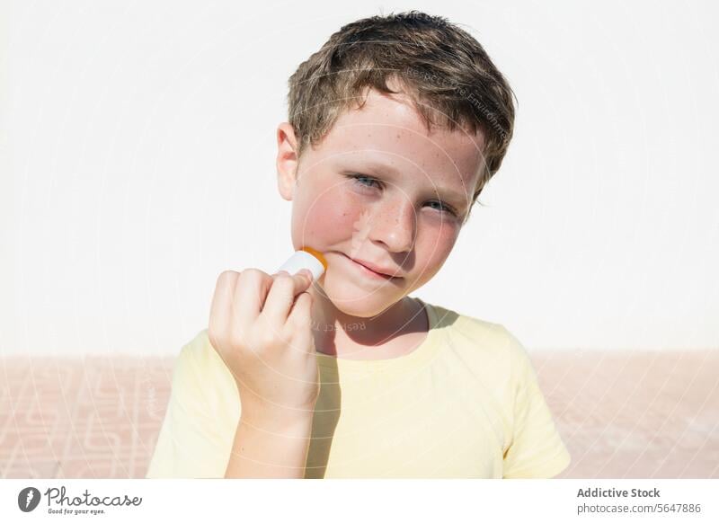 Young boy applying sunscreen on sunny day child protection skincare summer outdoor health safety sunshine facial care cream application preventive