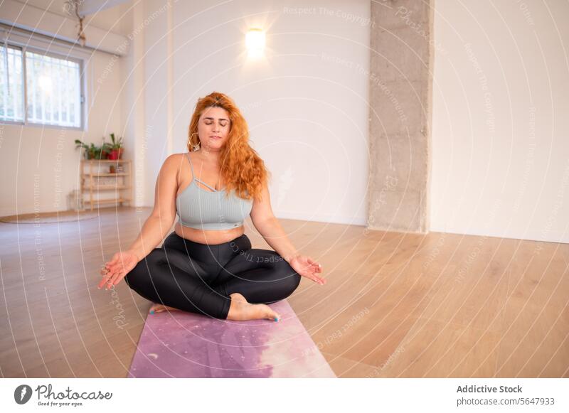 Concentrated curvy woman in yoga asana pose in yoga studio concentrate practice lady sportswear flexible barefoot fitness wellness stress relief stretch healthy