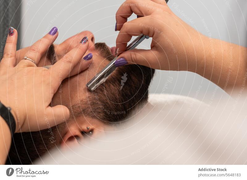 Crop unrecognizable hands of female barber shaving male client's beard with straight razor at salon Hairdresser Shave Straight Razor Beard Man Salon Care