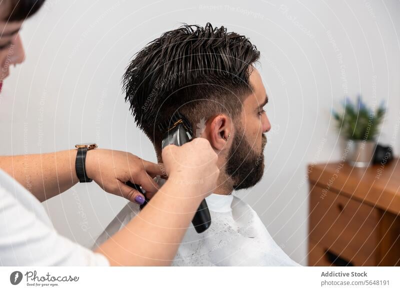 Cropped unrecognizable female hairstylist using electric trimmer on male client's hair at salon Hairdresser Trimmer Man Salon Care Service Hand Client Process