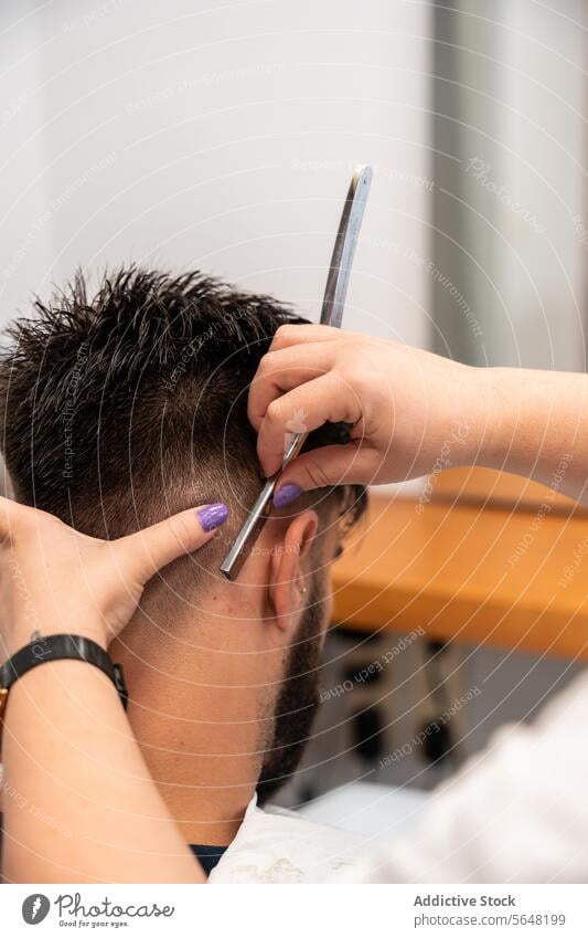 Cropped unrecognizable hands of female barber styling male client's hair with straight razor in salon Hairdresser Straight Razor Man Haircut Salon Care Service