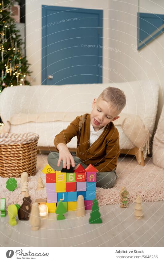 Little boy playing with blocks in living room against Christmas tree child playtime colorful carpet glow holiday season innocence fun engaging stacking joyful