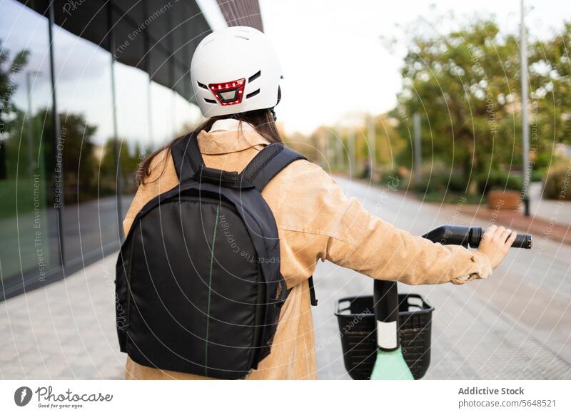 Urban cyclist with helmet and backpack holding smartphone urban commuting building standing young binoculars city transportation mobile phone safety gear